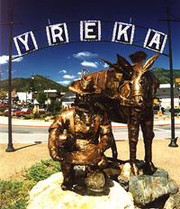 Bronze colored statue of kneeling gold miner with donkey standing beside, sign with 'Yreka' hangs above