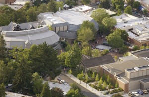 Aerial view of the OSF campus, white curved buildings among the trees, brown building to the side