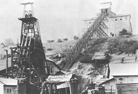 Black and white image of gold mining tower, chute, and processing building