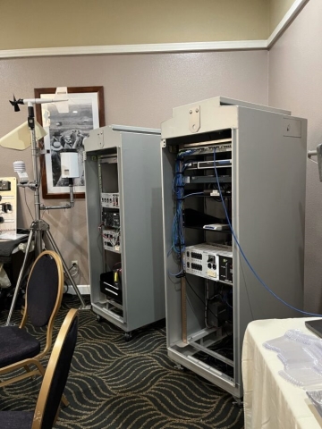 Two large metal cabinets holding communications equipment stand in the corner of a room.