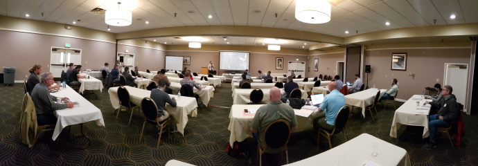 Meeting room with participants listening to a speaker during the 2021 Forum.