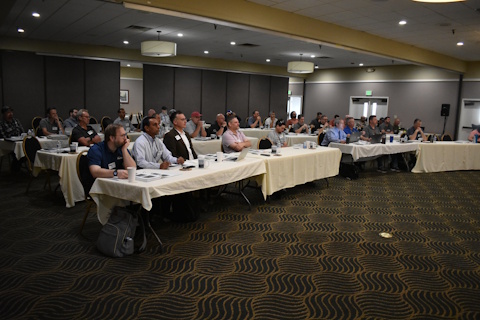The 2024 Western States Forum audience is sitting at tables arranged classroom style watching a technical presentation.